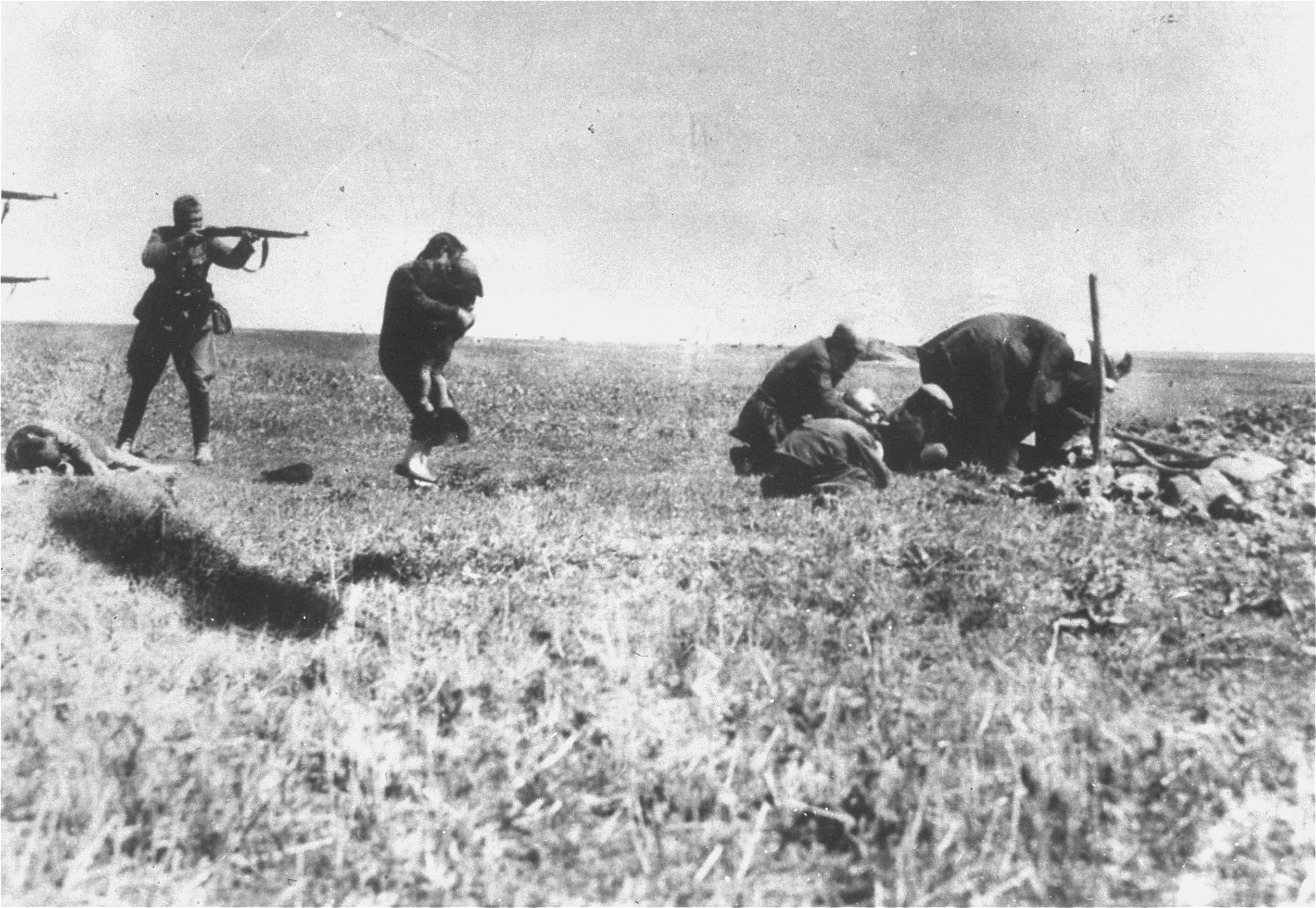 A German policeman aiming his rifle at a Jewish woman and her child. Ivangorod